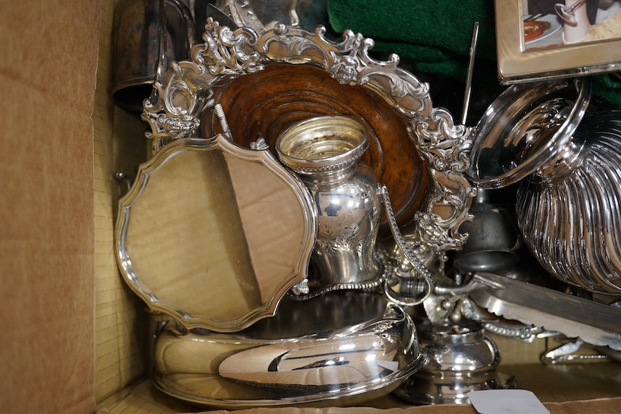 A quantity of assorted plated wares including a hot water jug, an egg coddler, salts, an entrée dish and cover, a crumb scoop, a horn handled fork, knife rests, trophy cups, a cream jug, a tea pot stand, together with tw
